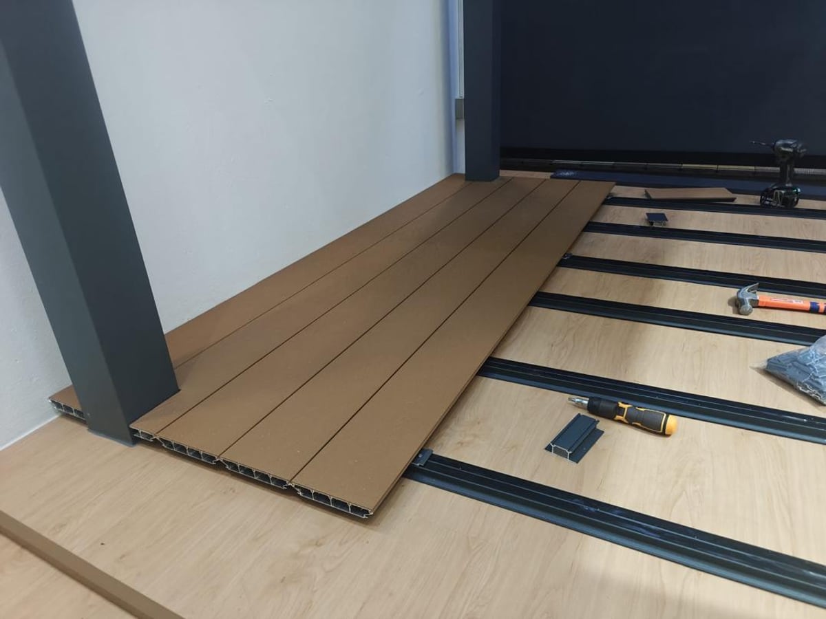 Aluminium decking boards being laid on an outdoor floor in Singapore